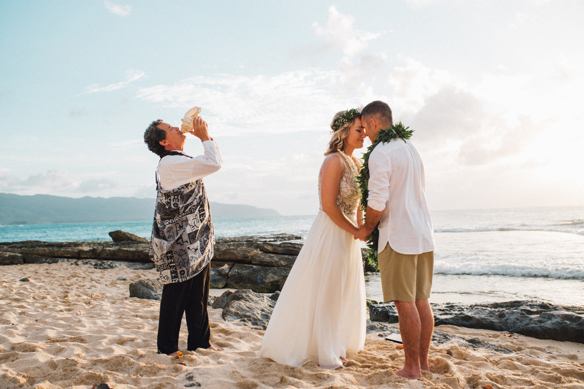 Bride and groom exchanging  ha during Hawaiian wedding tradition