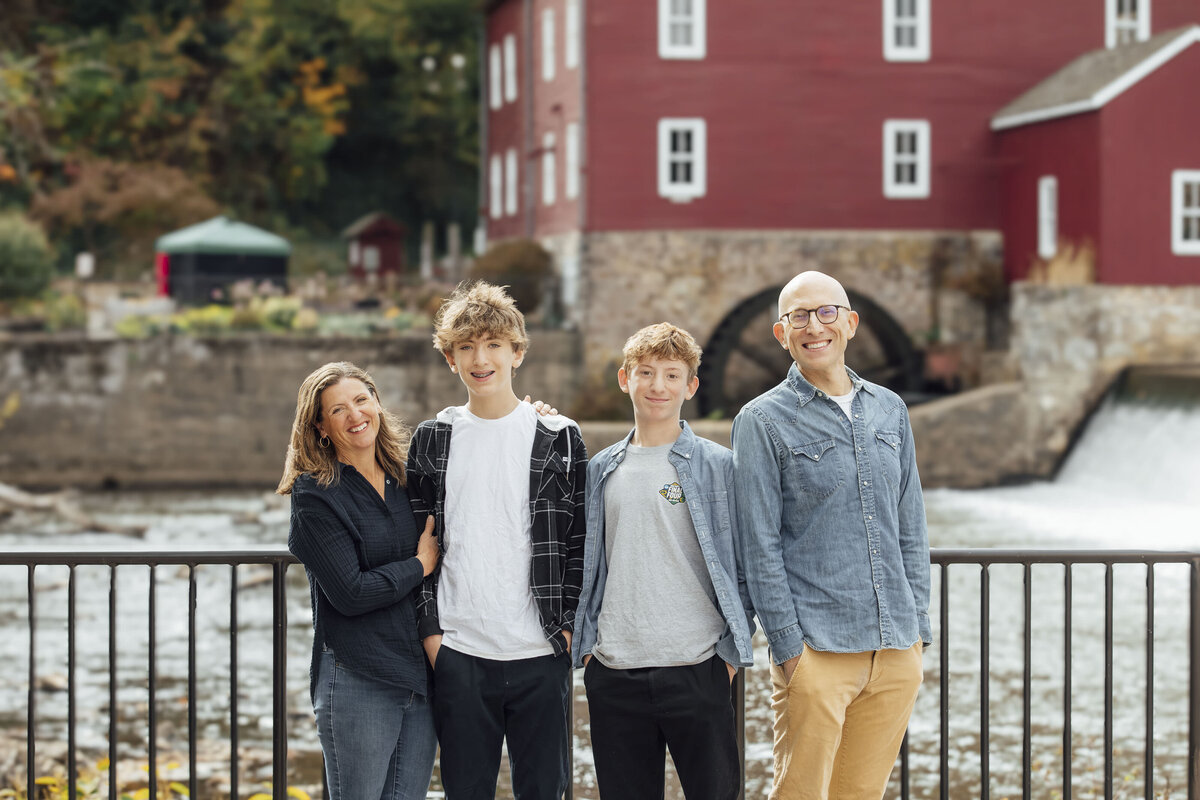 Family Photographer | Family posing together surrounded by colorful fall foliage near the Red Mill Museum | Clinton, New Jersey