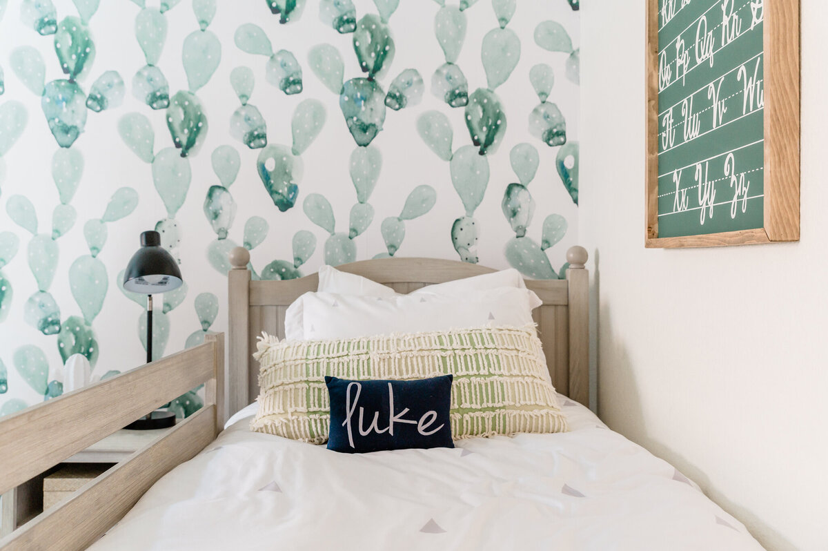 Child's  bed with a monogrammed piillow in a cactus themed bedroom
