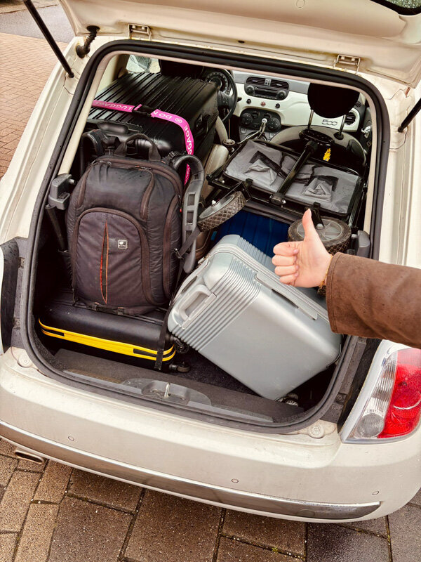 Lots of bags and suitcases fit in the back of a car