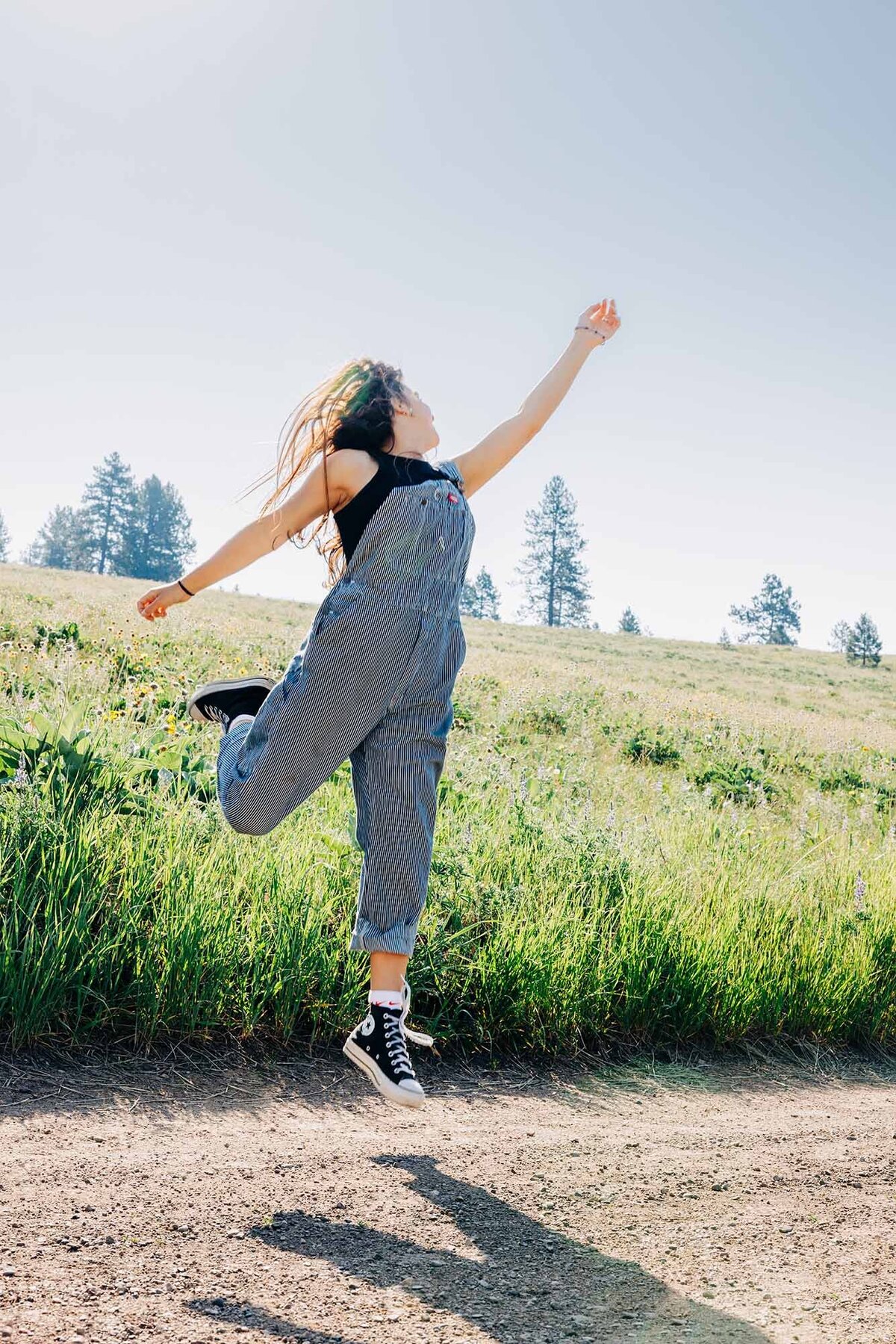 Senior photo girl jumping at North Loop Trail, Missoula