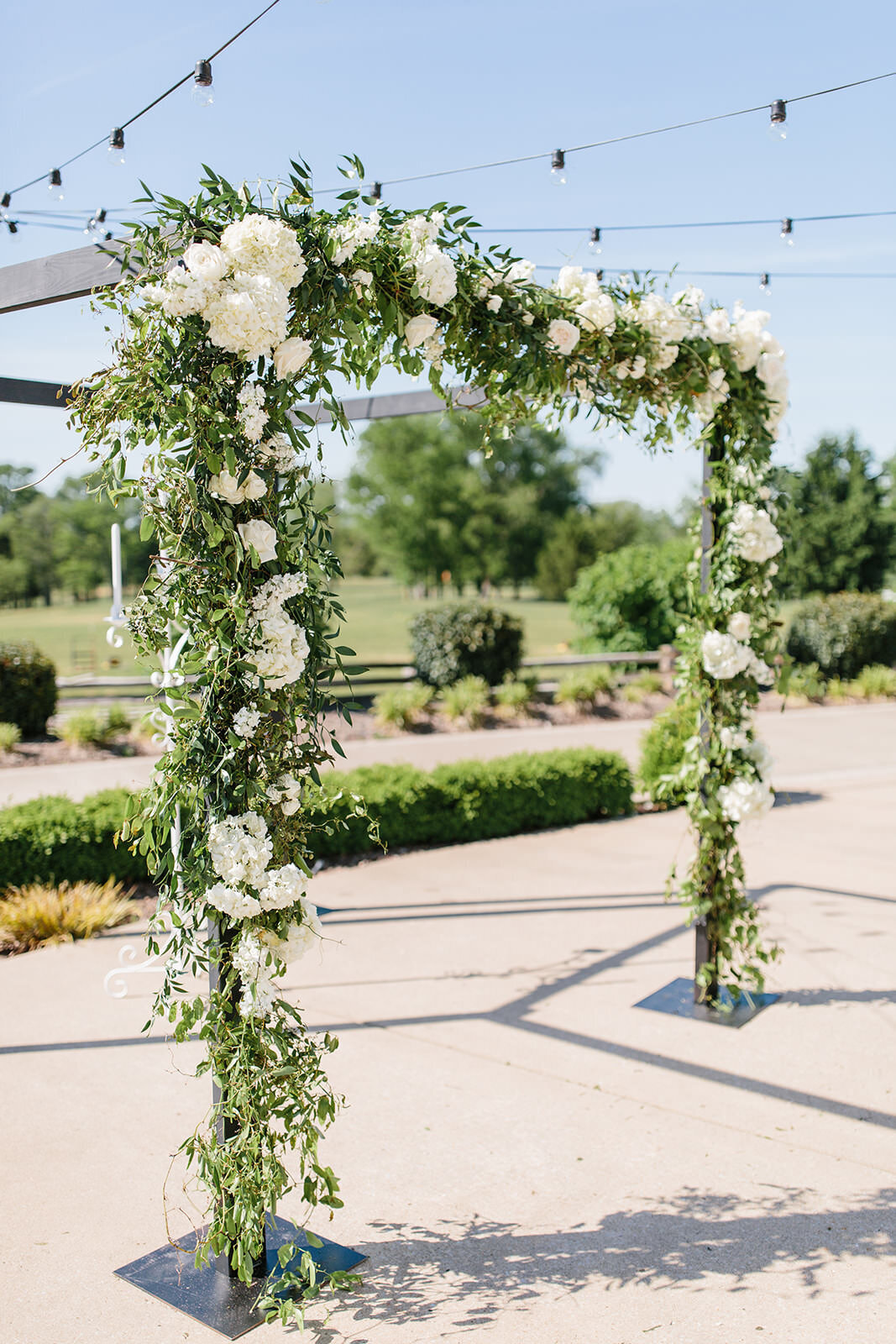 Chuppah covered in white flower  and mixed greenery at Stones River Country Club in Murfreesboro, TN