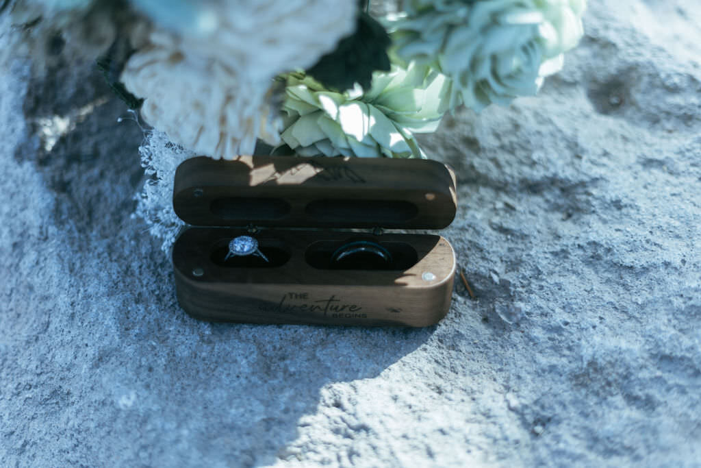 Wedding rings in a box on a rock.