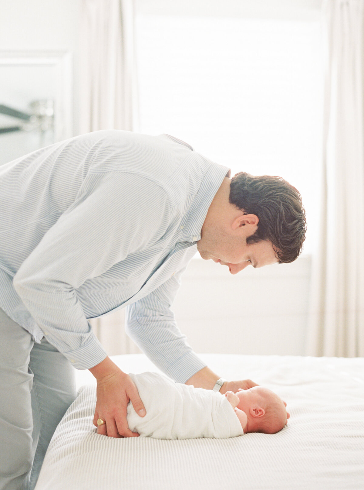 Dad comforts new son. Image by Raleigh newborn photographer A.J. Dunlap Photography.