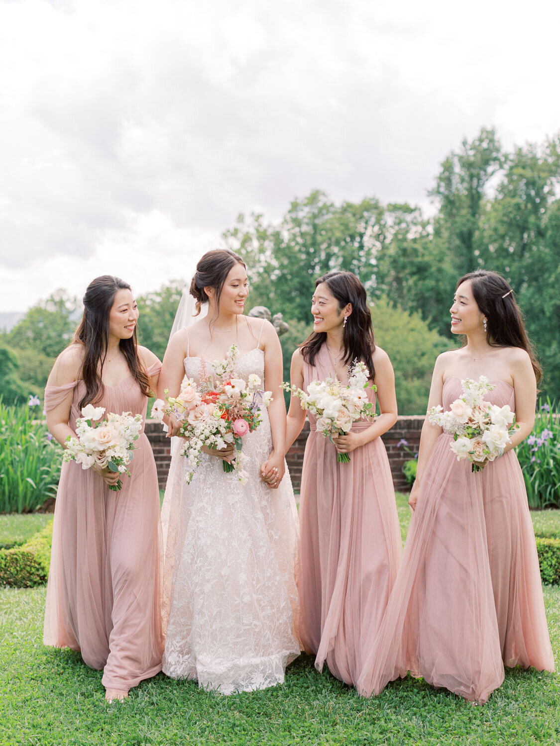 Bride with bridesmaids in blush dresses outside