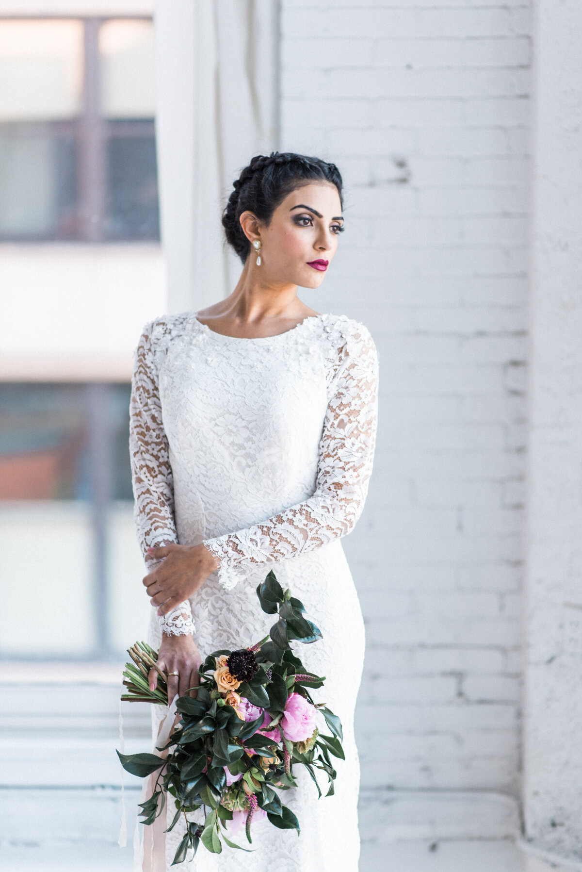 Hudson's bateau neckline is adorned with small 3D flowers and crystals which continue onto the shoulders of the sheer lace sleeves.