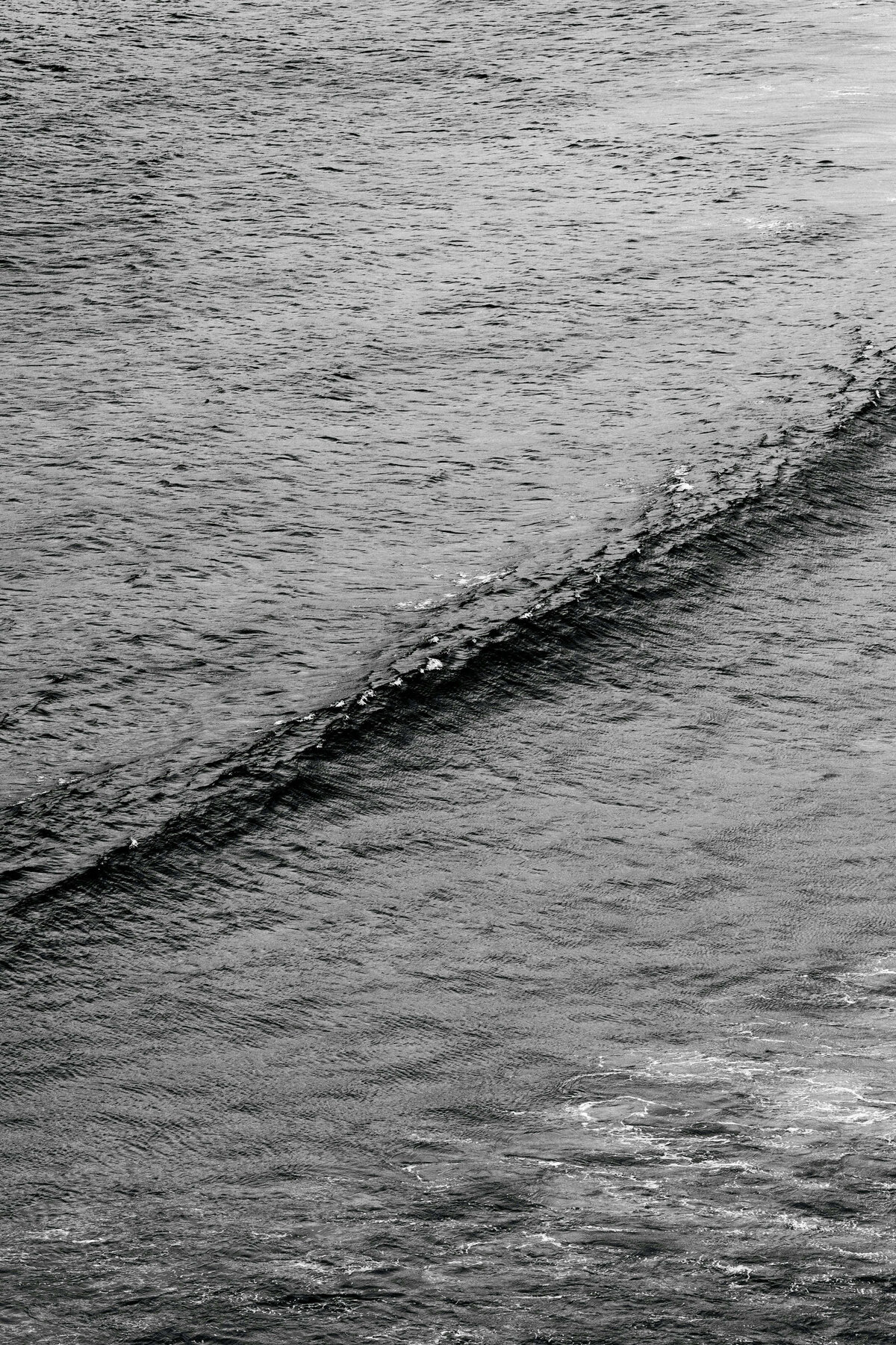 black and white aerial photo of an ocean wave