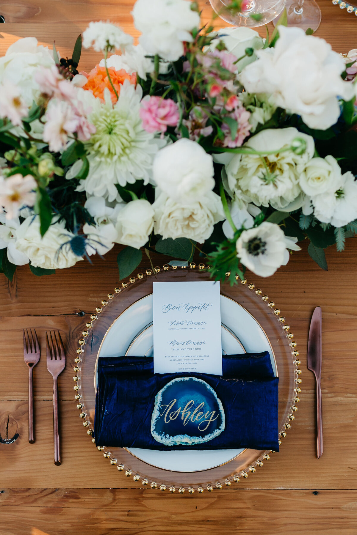Wedding reception place setting with floral and deep blues