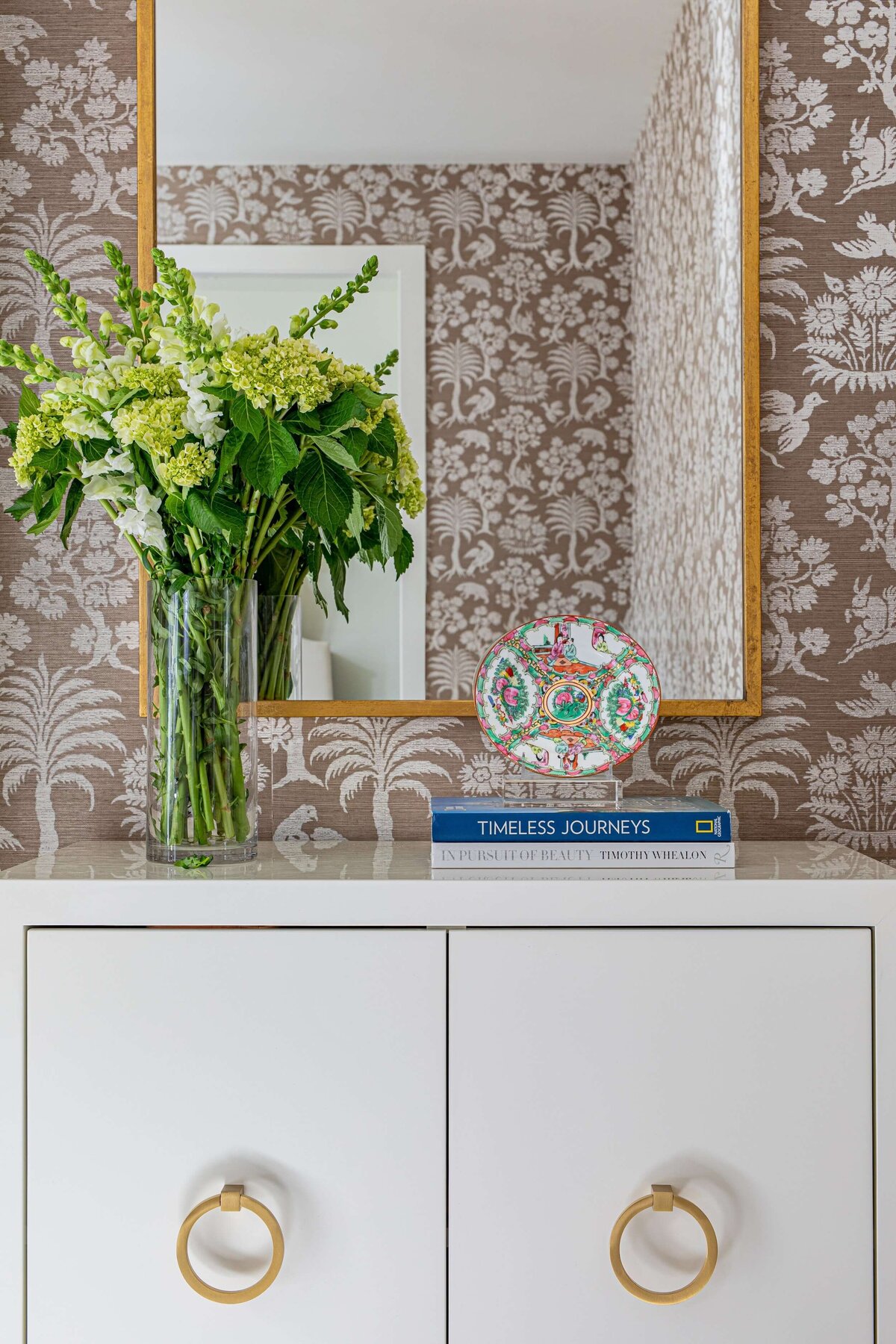 oyster creek studios highland park home  fresh flowers on white accent table in room with taupe wallpaper