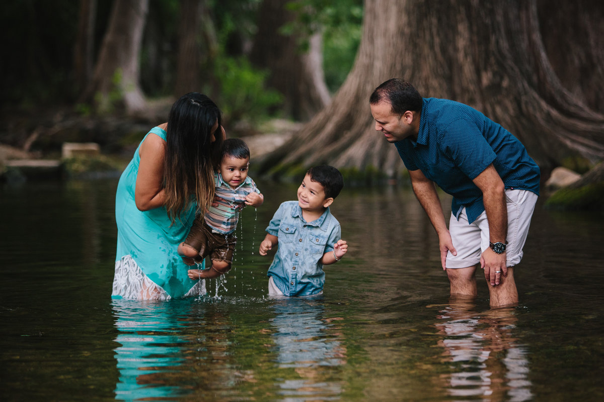 family standing in river water for a photography session by San Antonio photographer