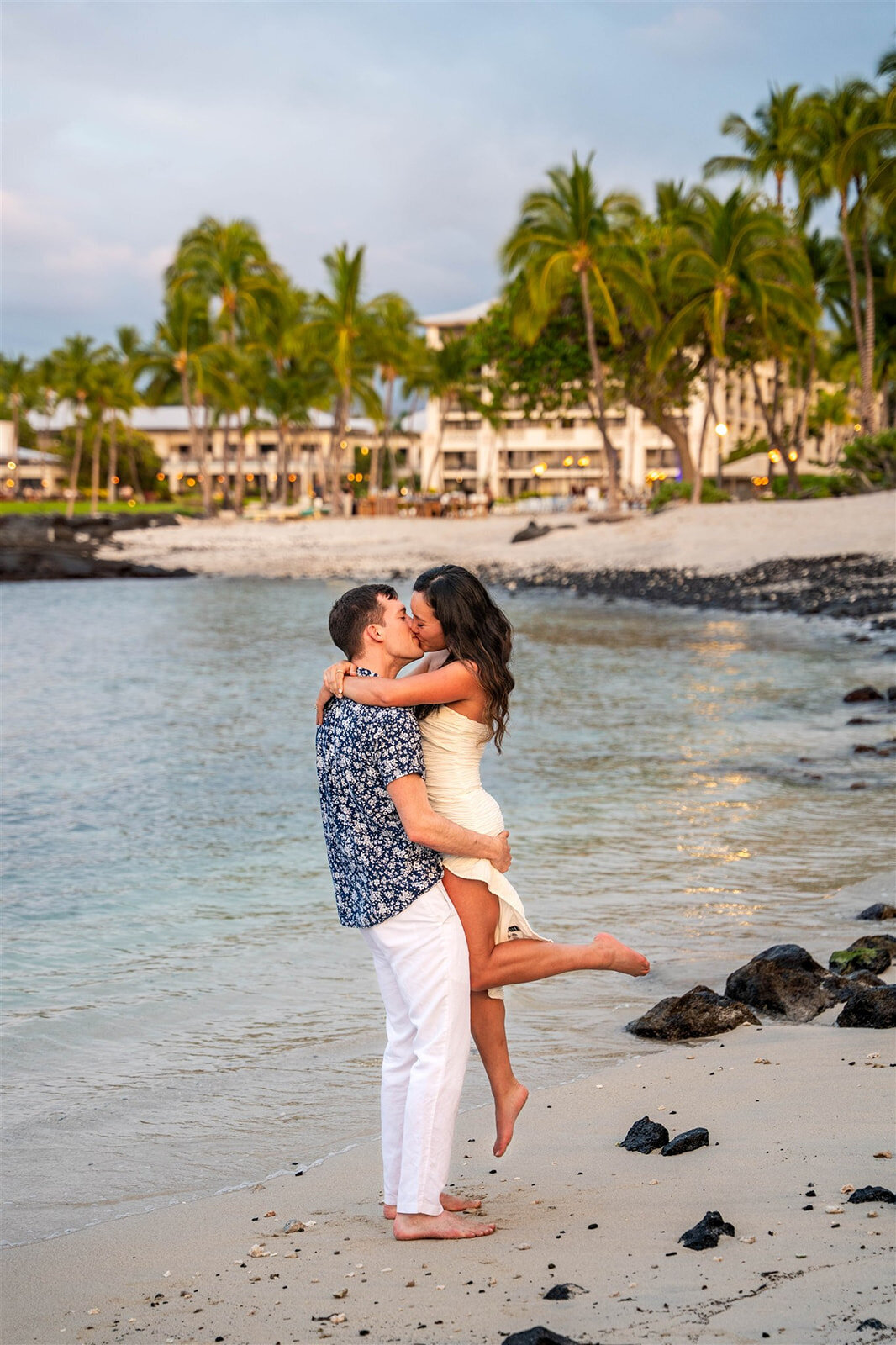 Couple kissing on the beach taken by engagement photographer in Hawaii
