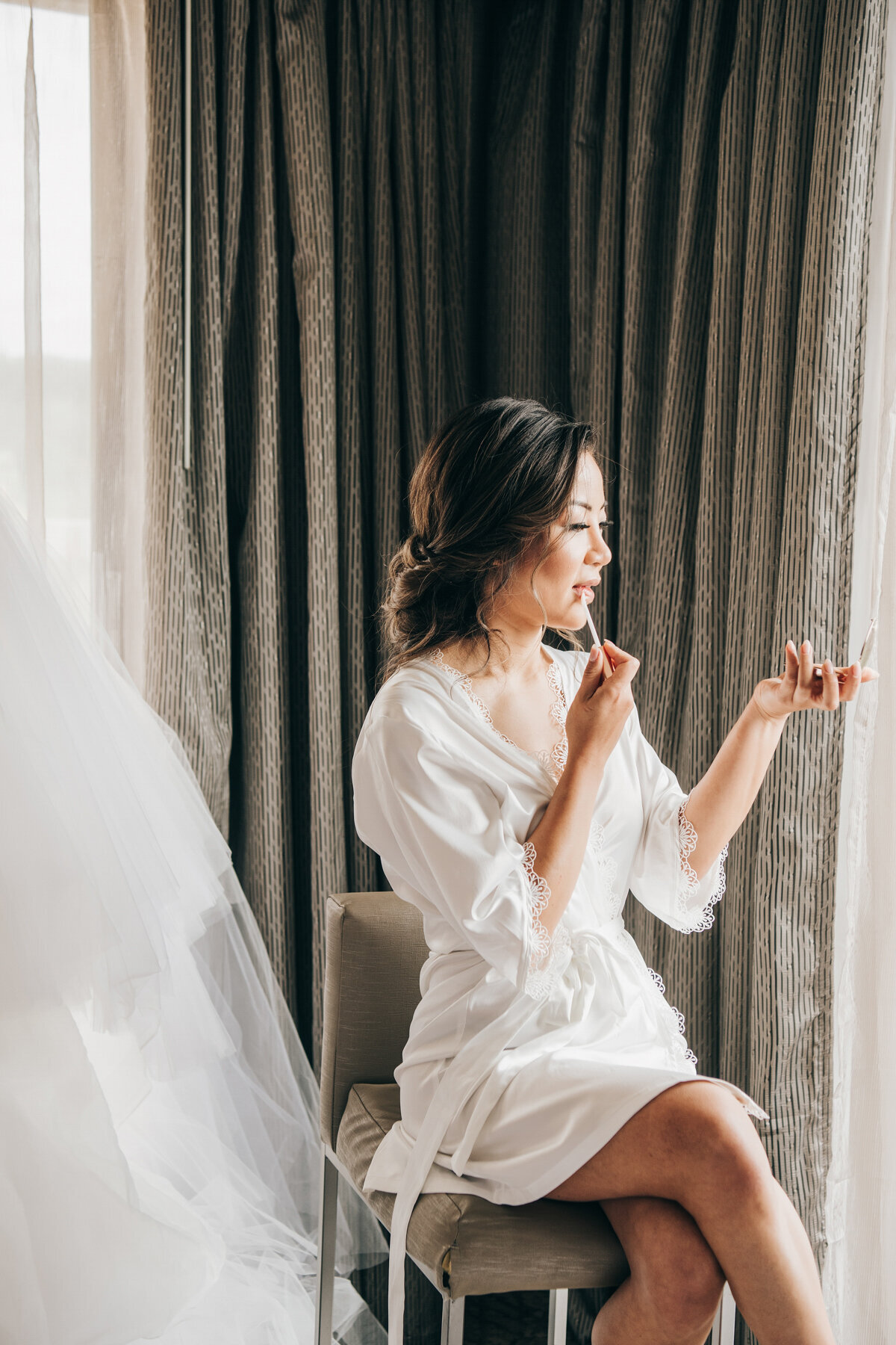 Glamorous bride getting ready with lip gloss