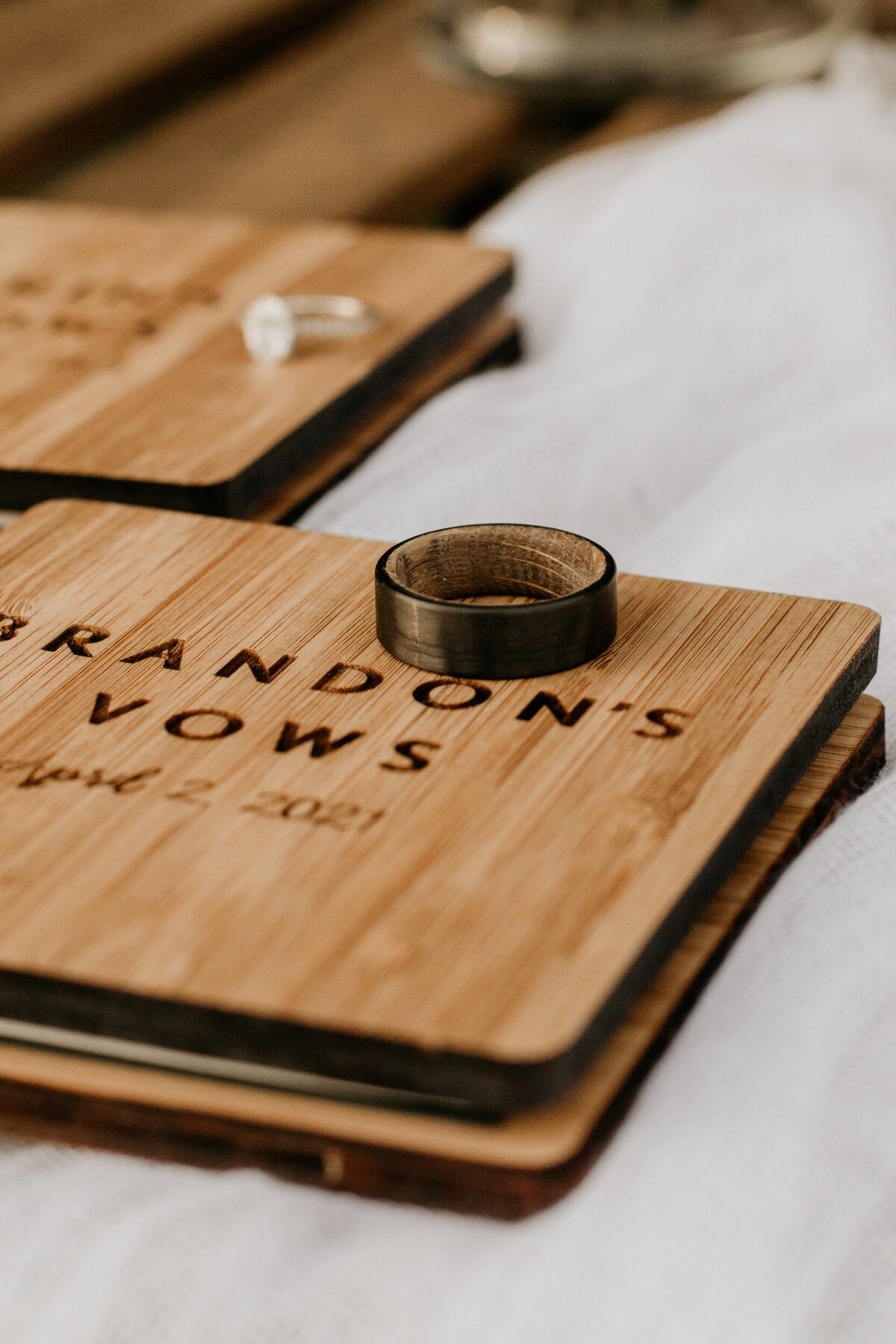 bride and groom rings with wooden vow books