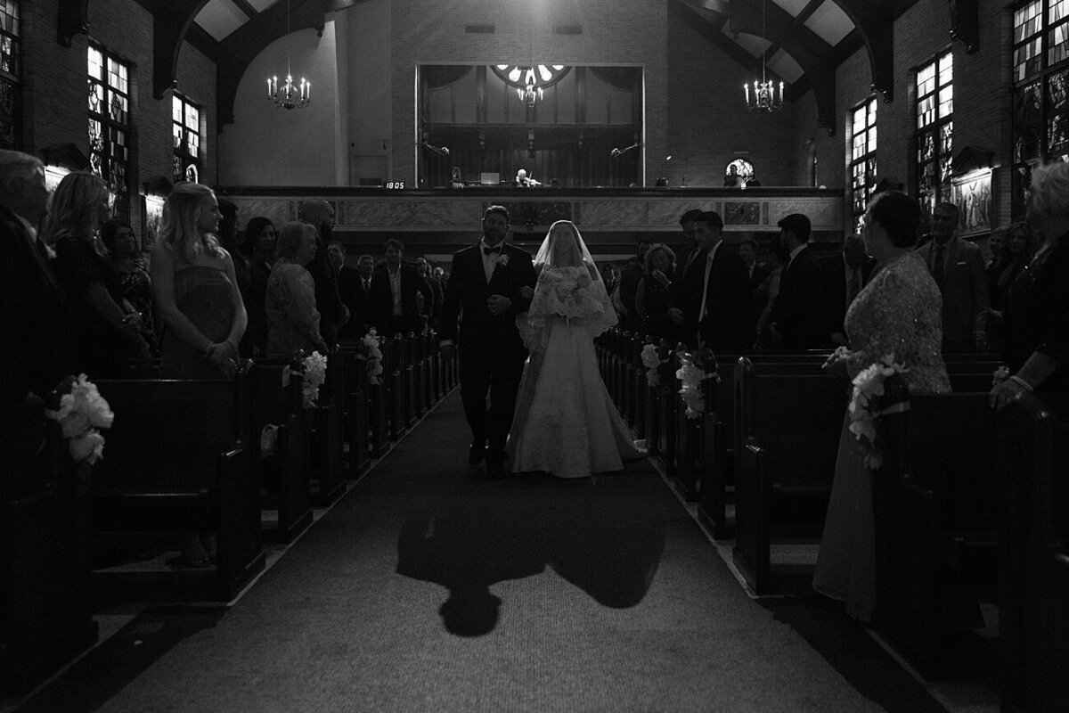 bride and her father walk down the aisle at church