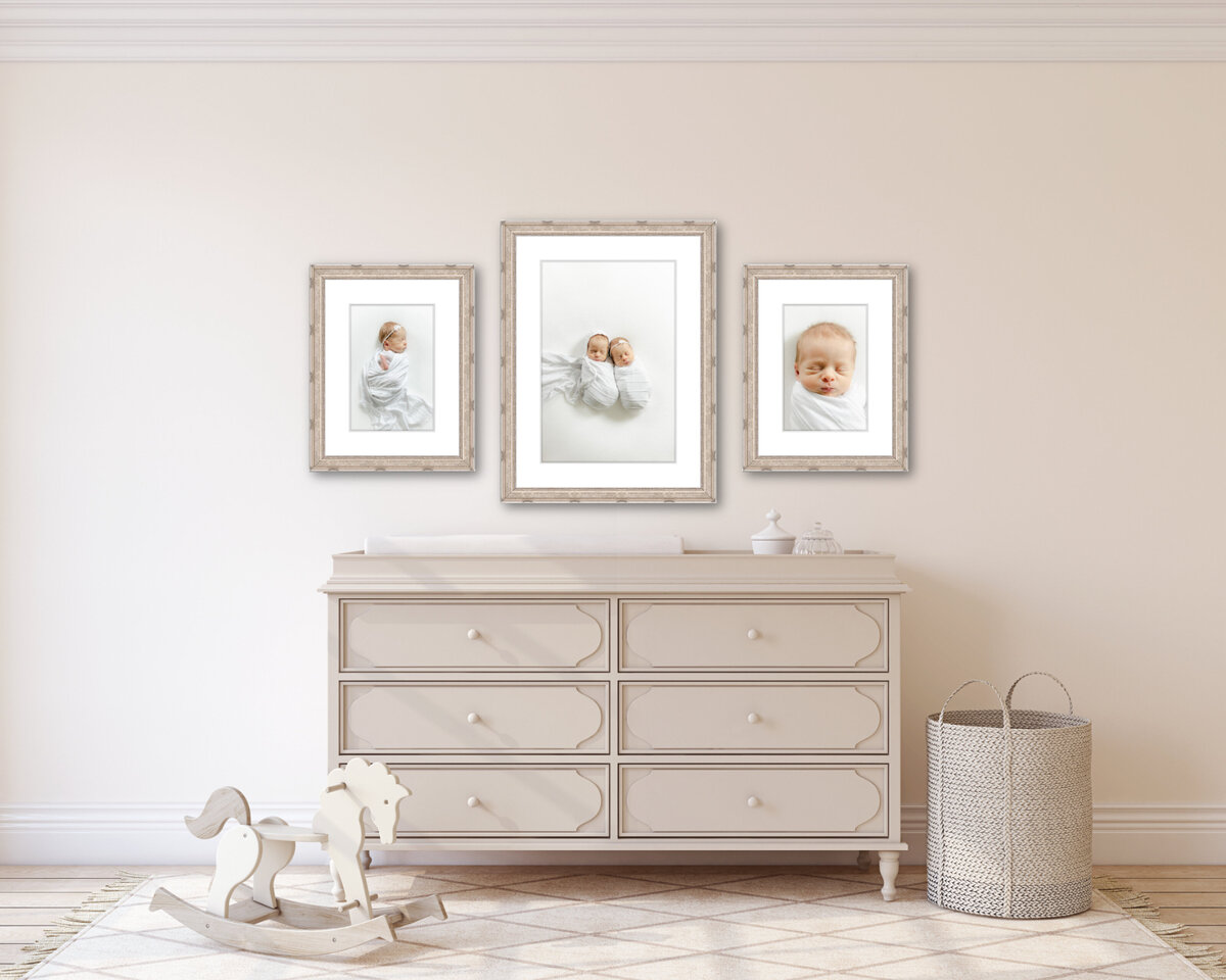 A cream nursery wall featuring three framed pictures of twin babies wrapped in white from their Indianapolis newborn photography session.