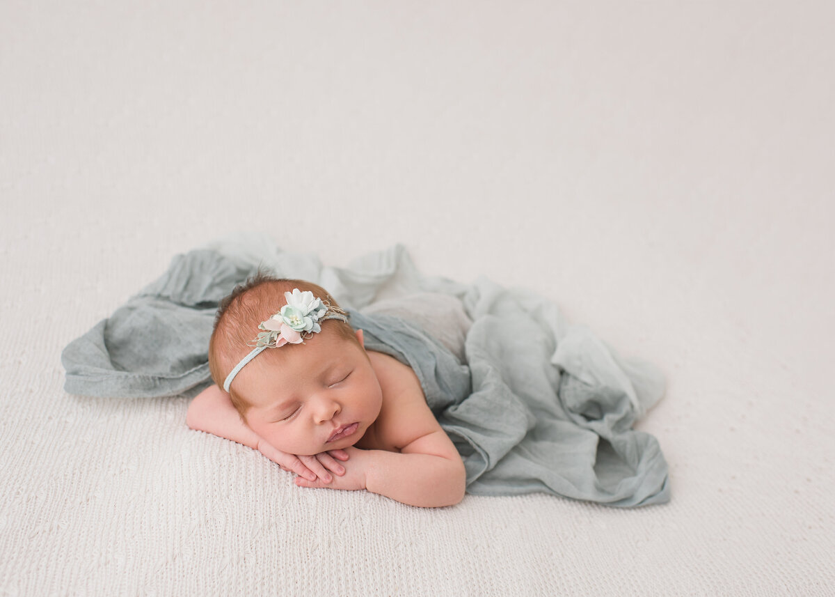 baby with a white headband and light blue blanket
