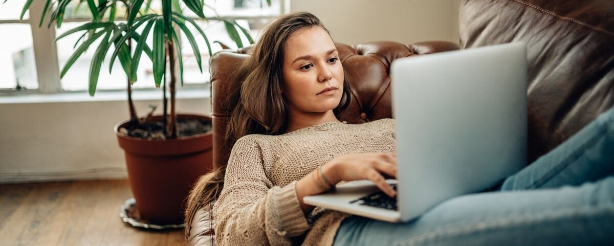 A close up of a woman resting on her sofa with a laptop. This could symbolize someone trying to search for support with their relationship issues. We offer support with online couples therapy in Florida, online couples counseling, and other services.