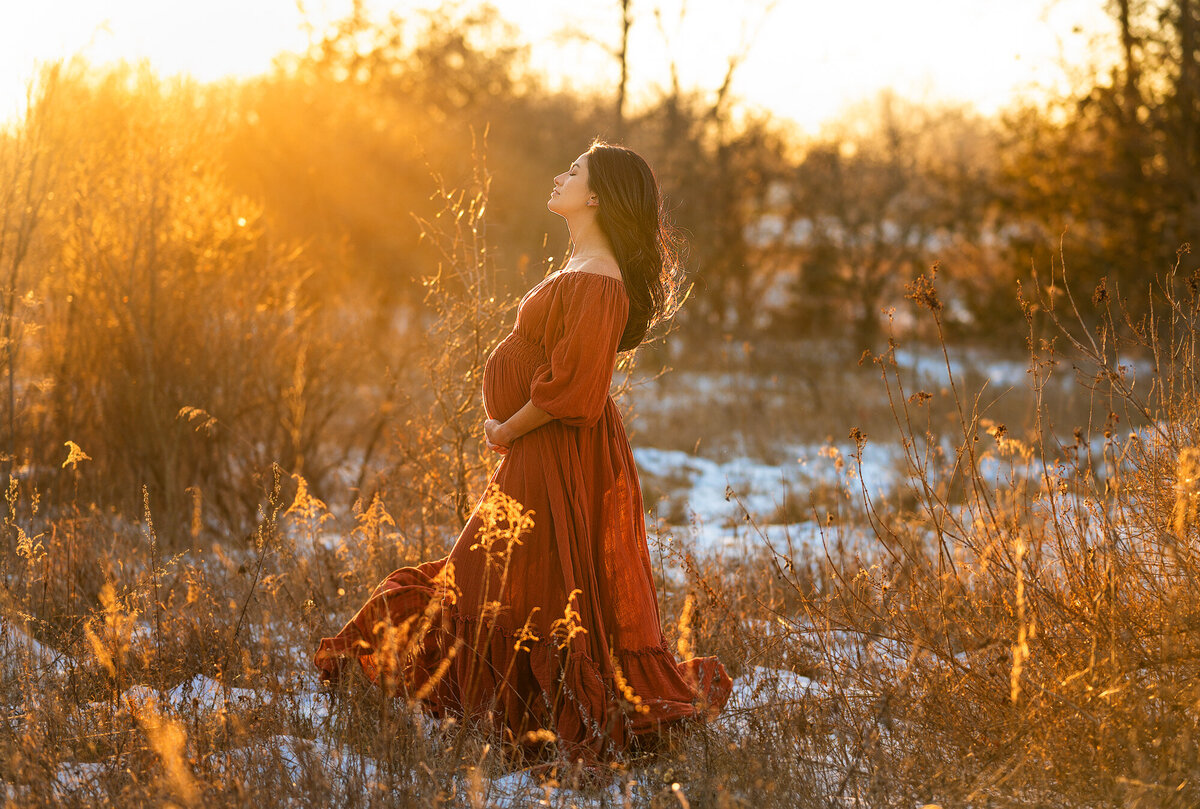 Pregnant mother wearing a red reclamation dress during golden  hour.