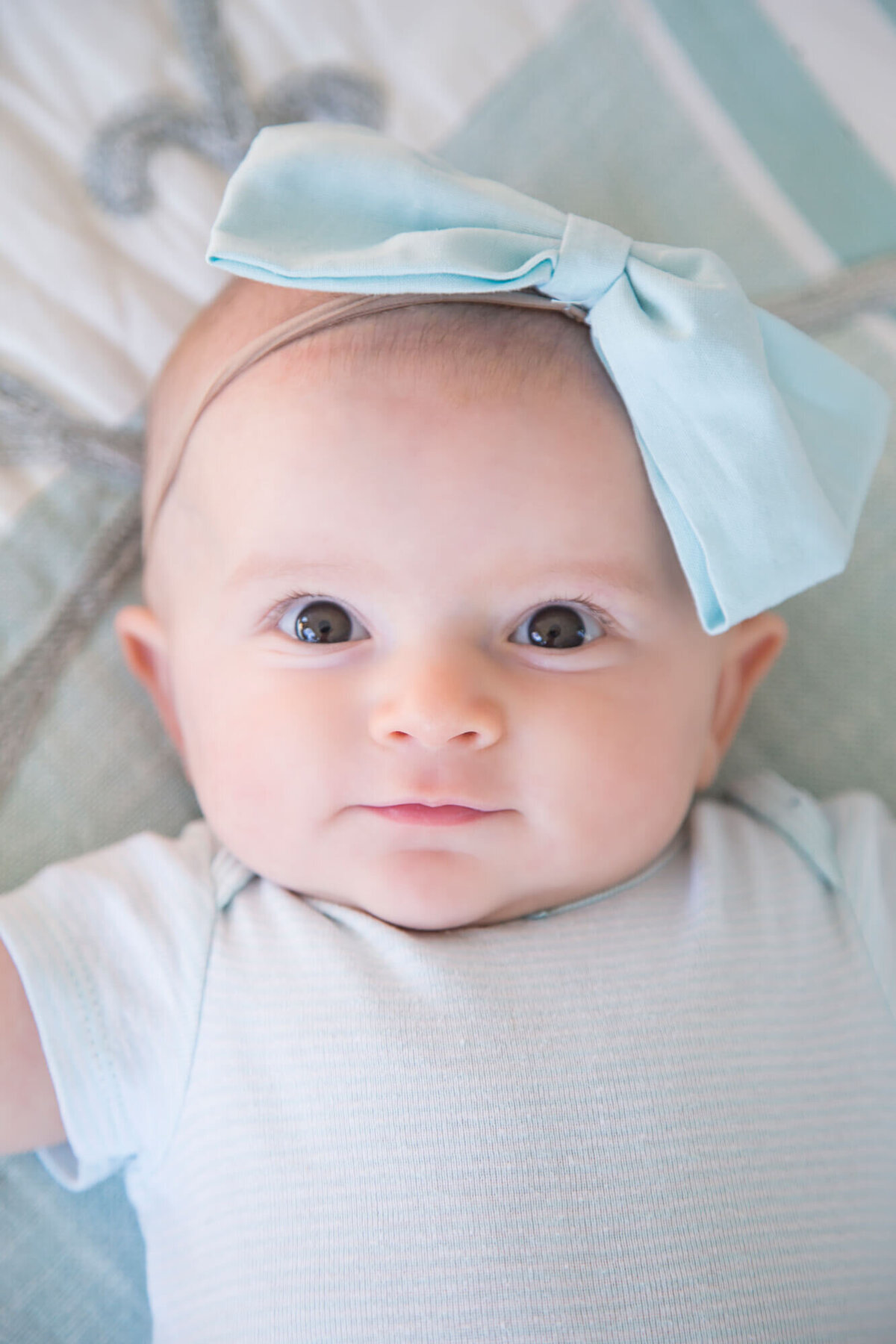 surprised baby girl in blue on a bed