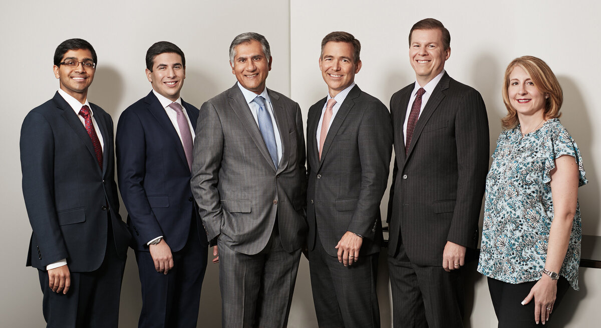 Formal group portrait of the Pheripas Capital team in professional attire, standing together and exuding confidence, captured by Ylva Erevall.