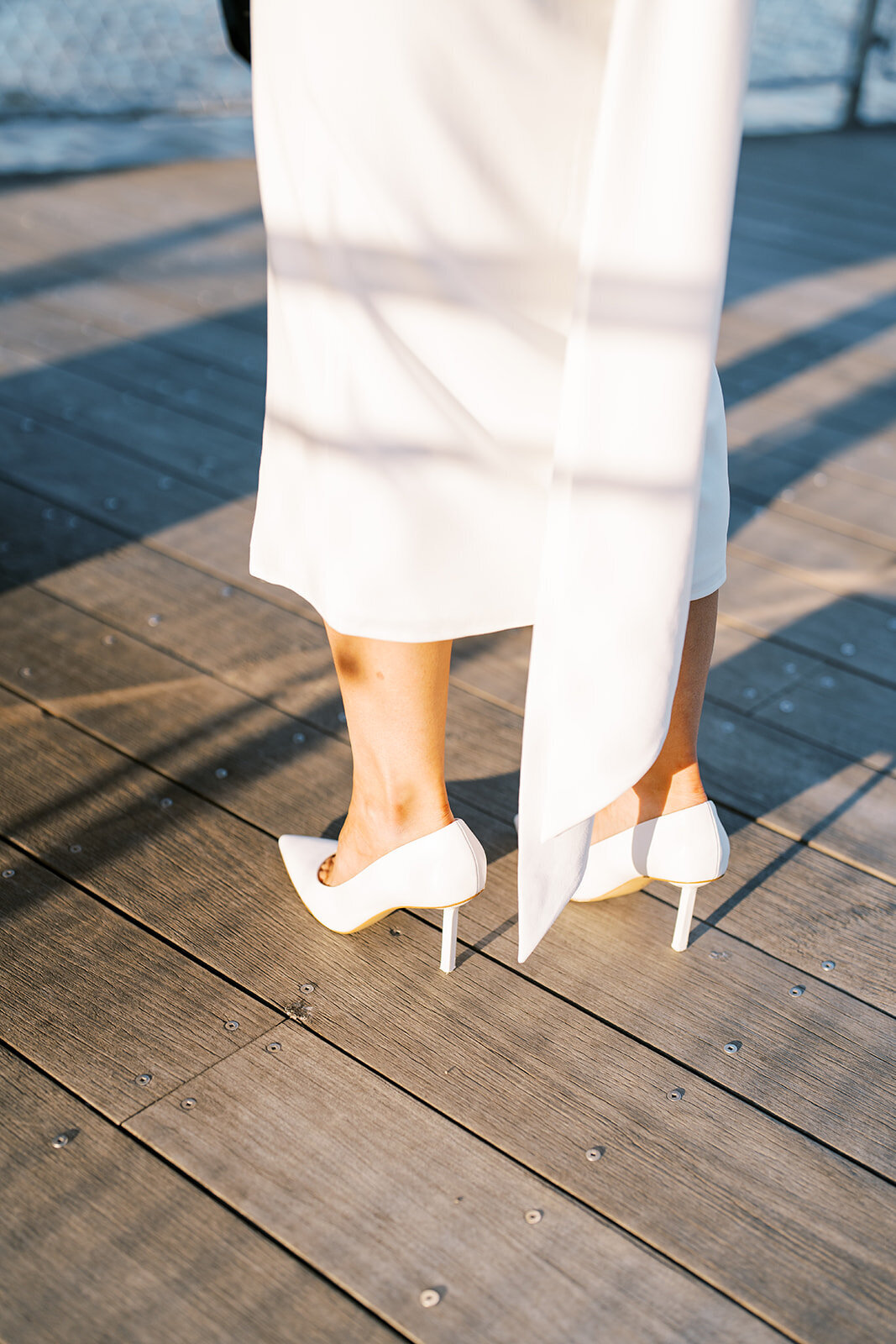 Close up details of bride's heels and dress