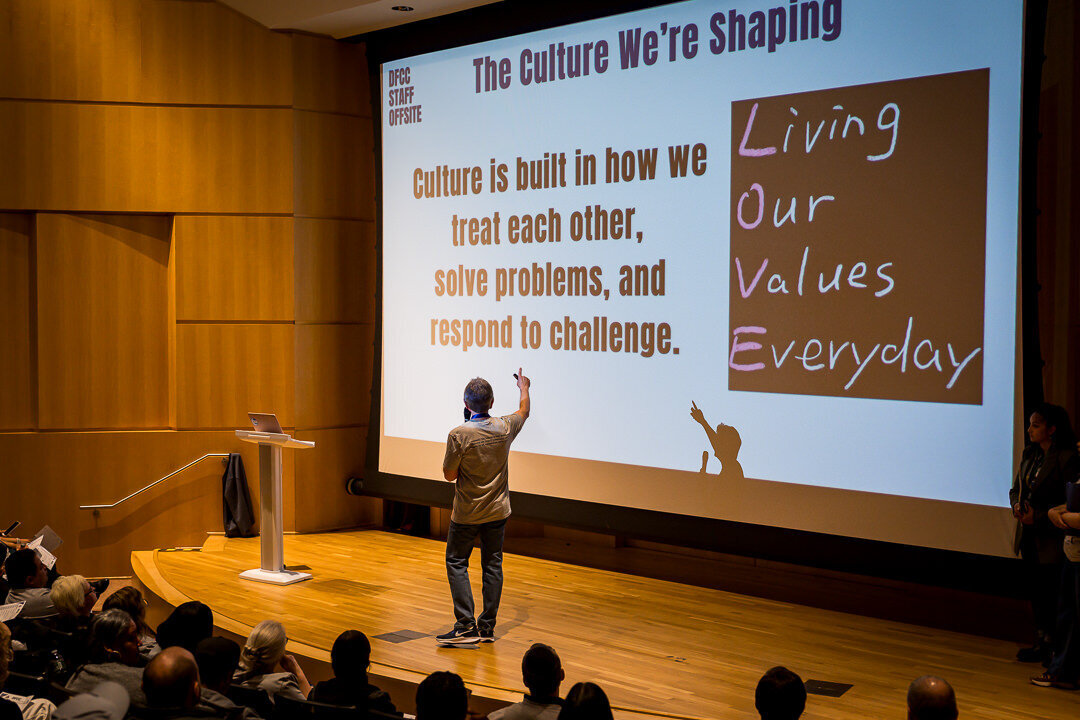 Corporate event photography of keynote speaker presenting confidently on stage during business conference new jersey.