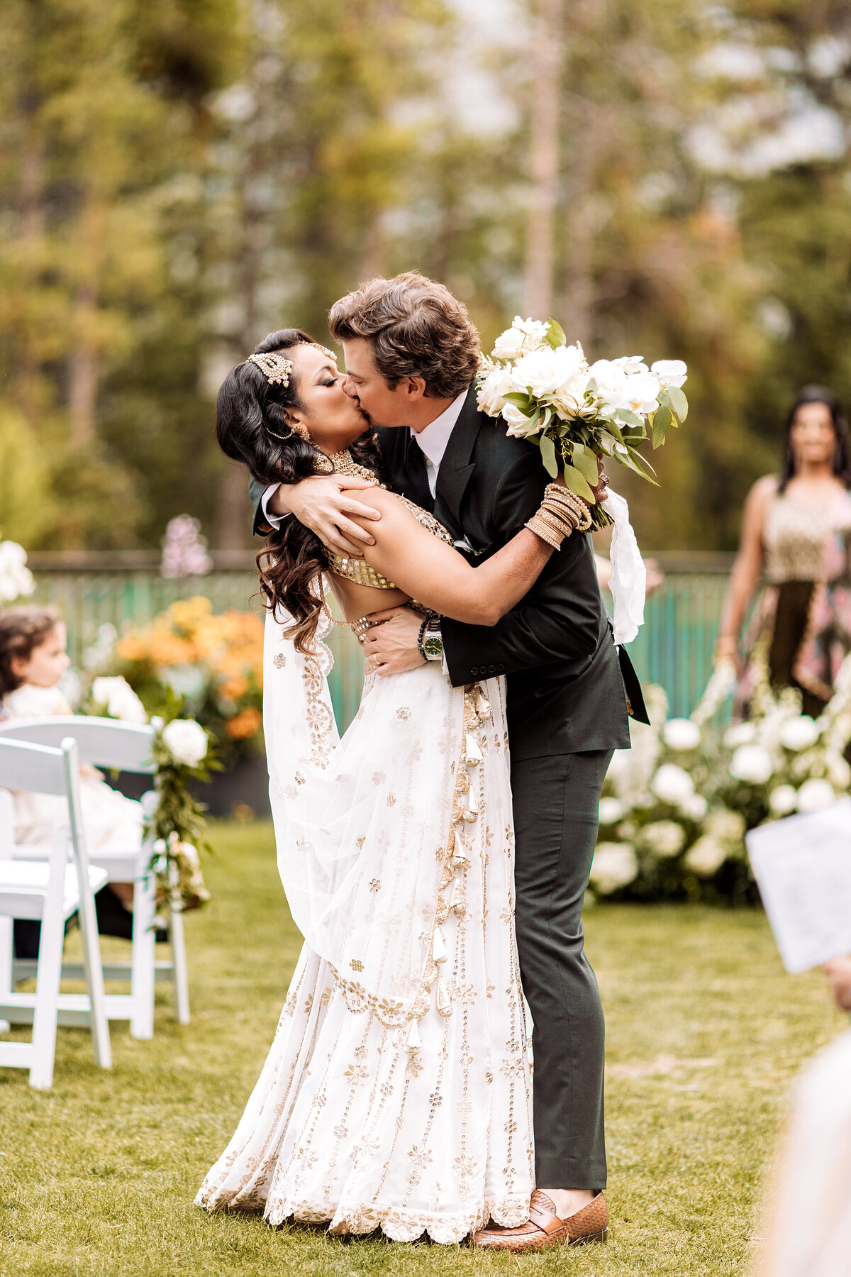 Newlyweds kiss halfway down the aisle at the Rimrock Hotel