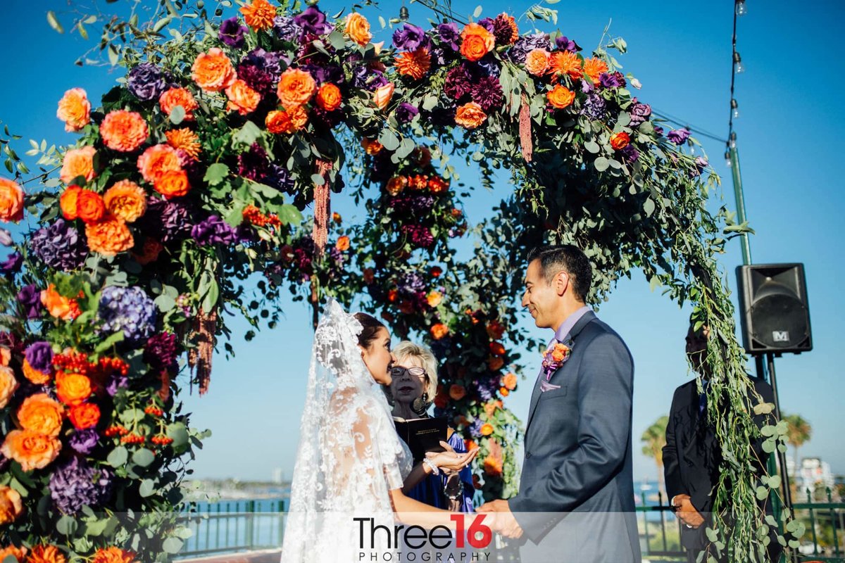 Wedding Ceremony with a beautiful orange flower arch