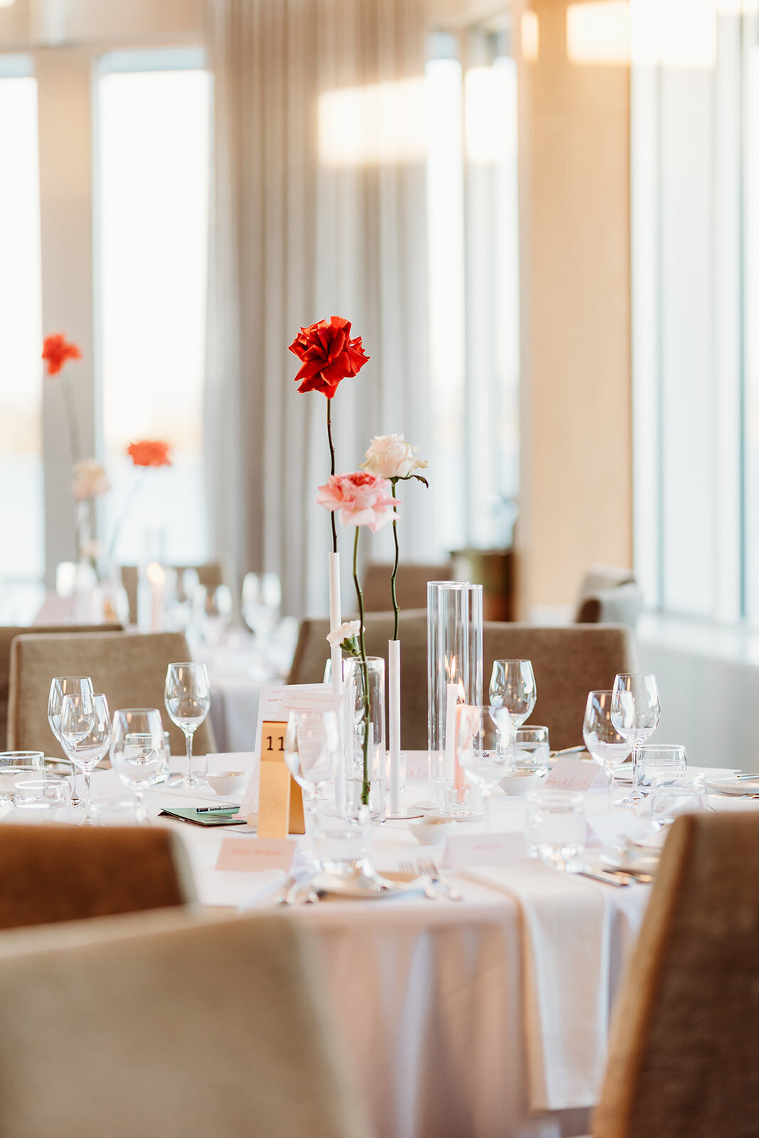 Red, pink and white roses in bud vases as wedding reception decor at The Marion, Canberra ACT