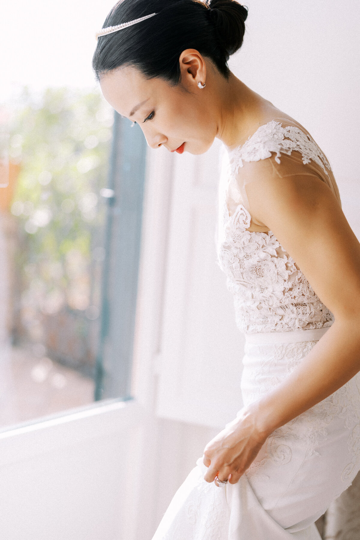 Bride adjusting her dress in soft window light before ceremony – Toronto wedding photography