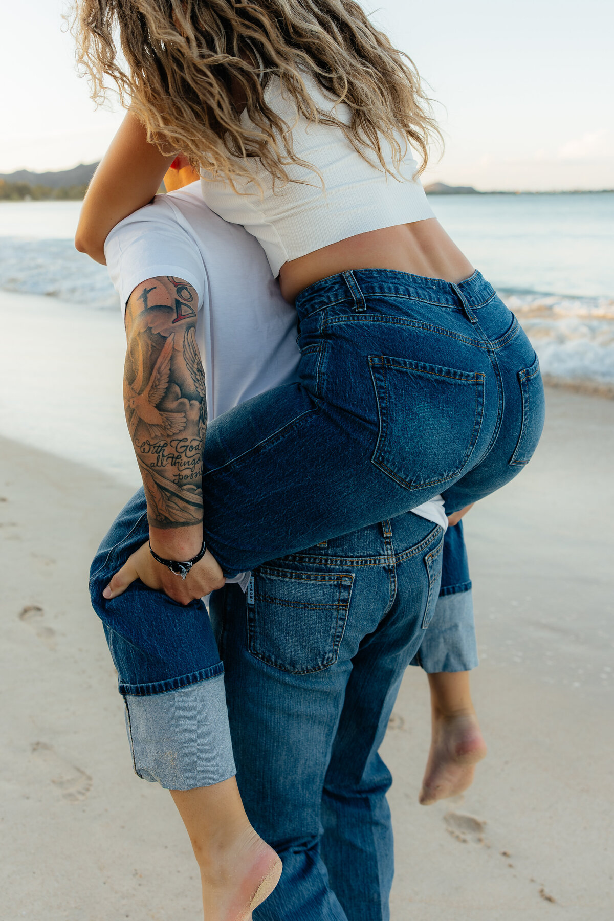 Close-up of couple during playful piggyback ride on the beach in Oahu