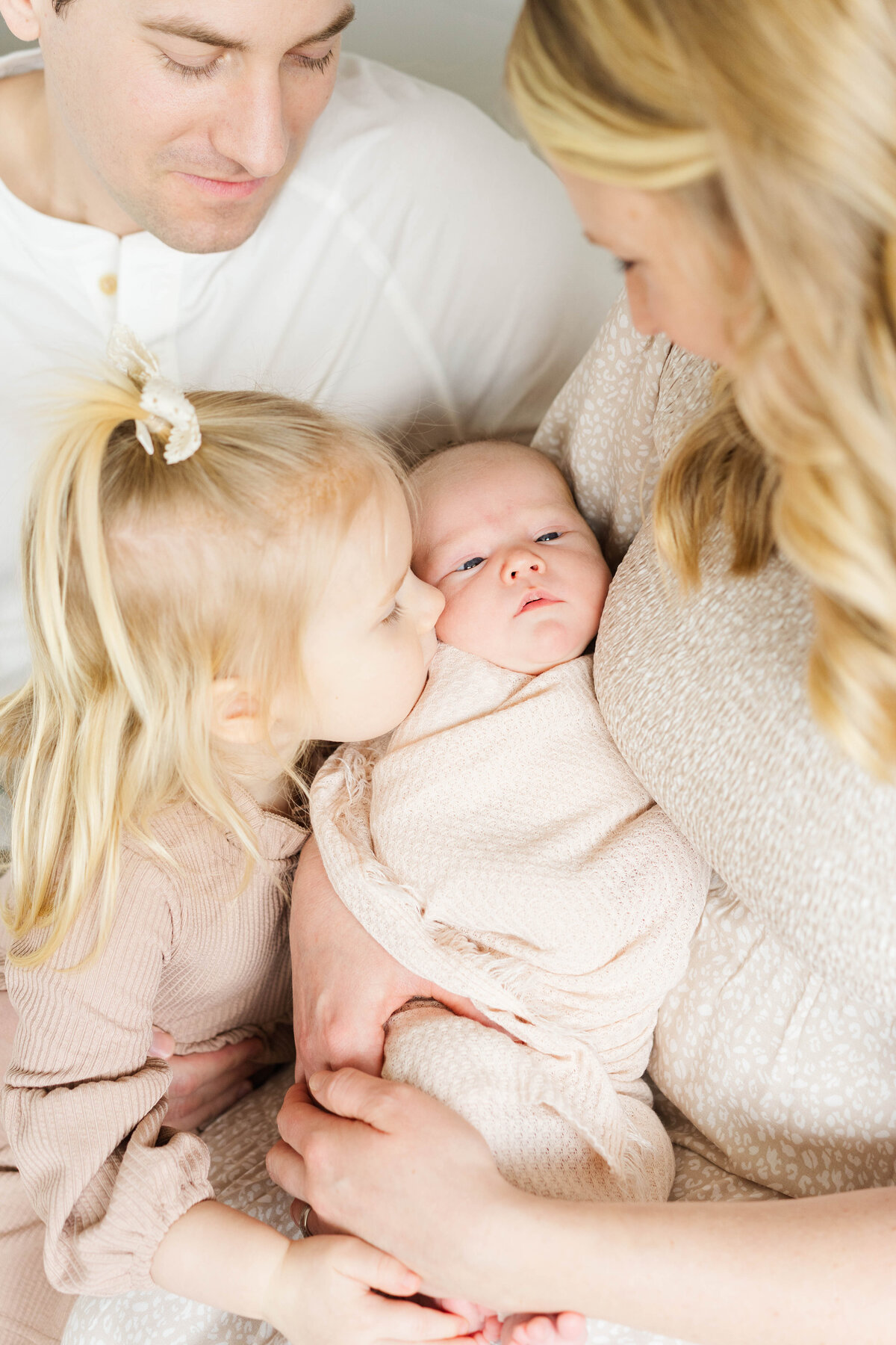 a family embraces their newborn and older sibling
