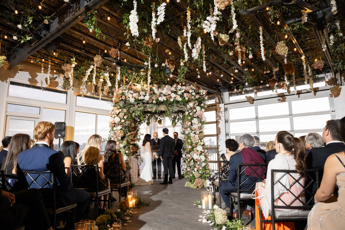 a wide shot of the ceremony showing the beautiful hanging florals