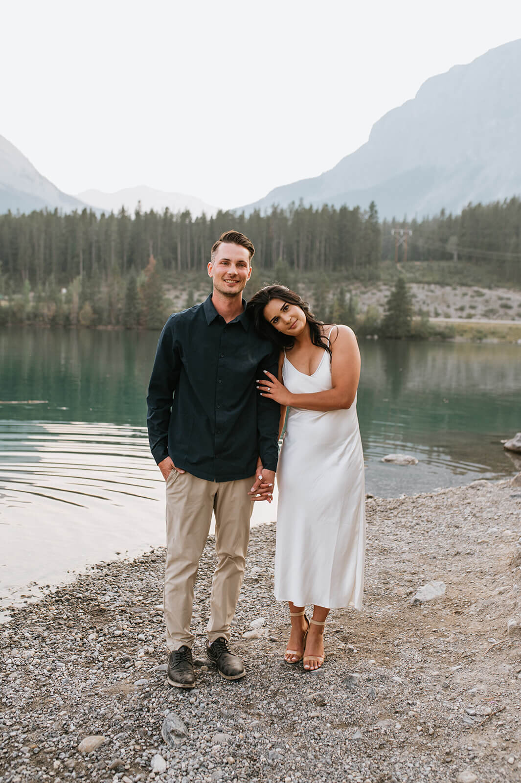 Enagagment-couple-standing-infront-of-water-and-mountains-Canada