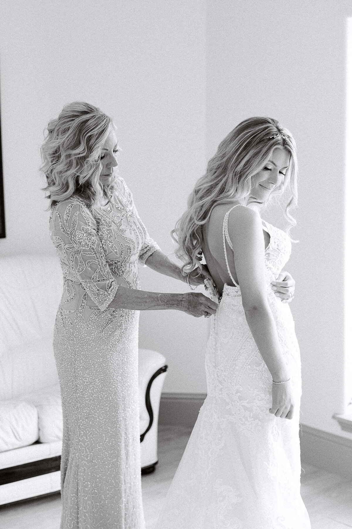 Bride's mother helps zip her wedding dress at North Texas wedding