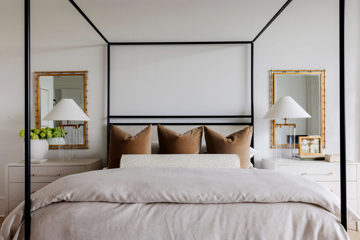 oyster creek studios hughes black canopy bed with white bedspread and brown pillows in bedroom