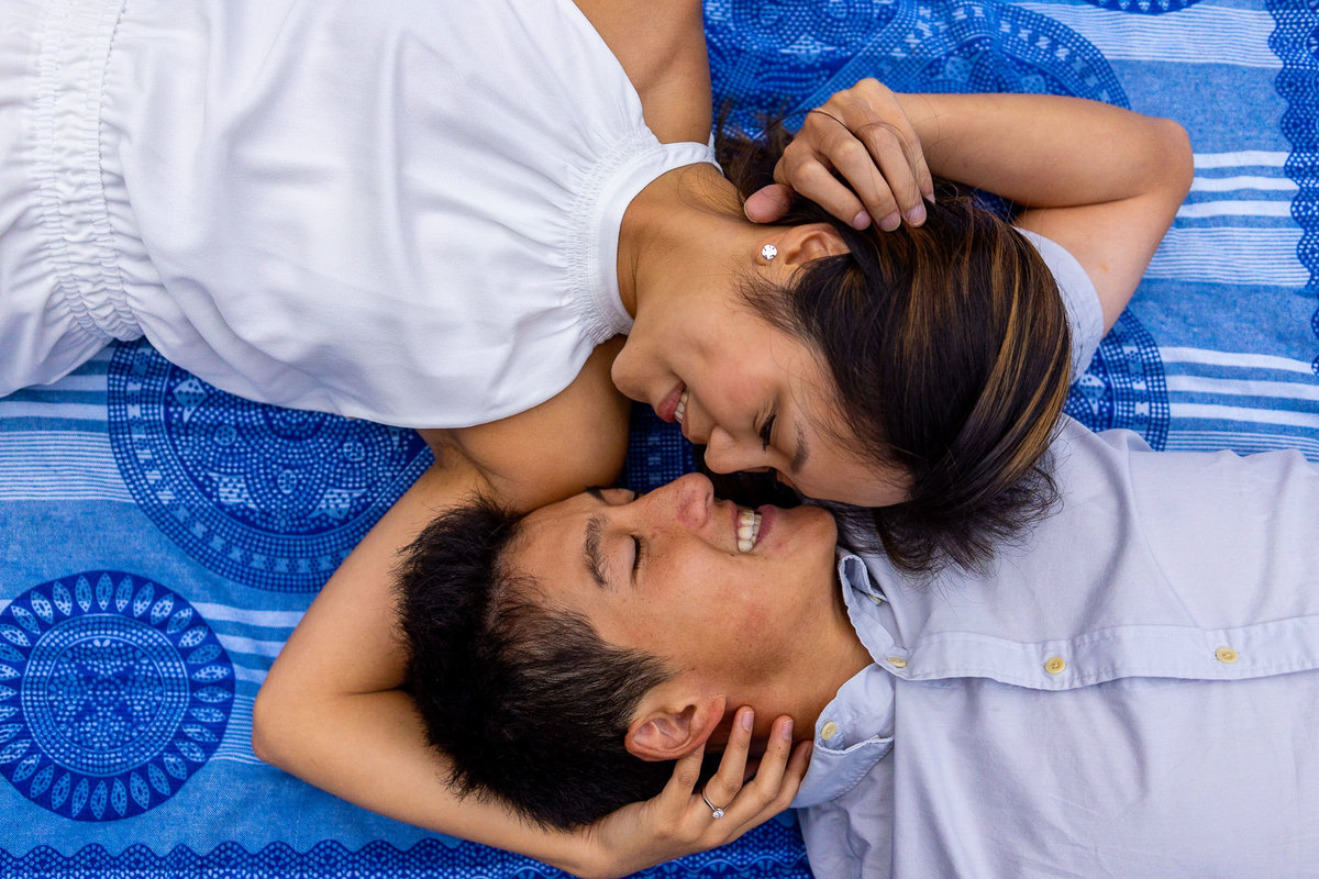 Couple laying down holding each other during their Othello Tunnels engagement