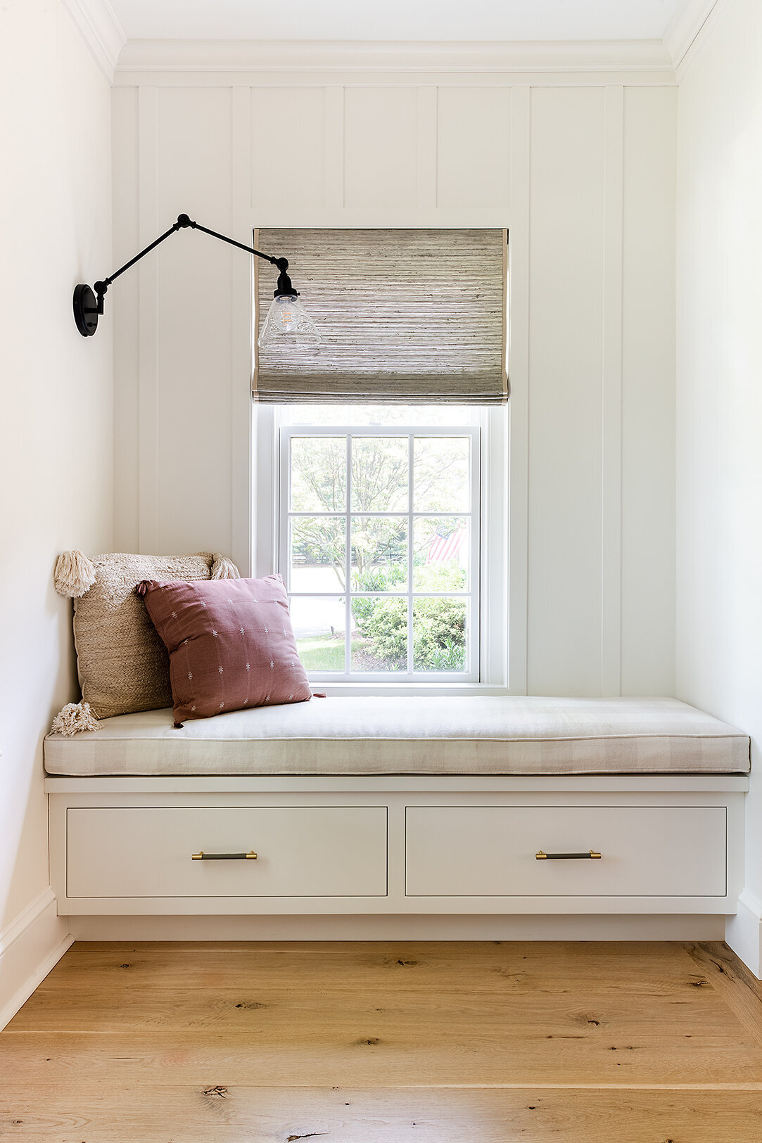 neutral colored window seat with window overlooking garden