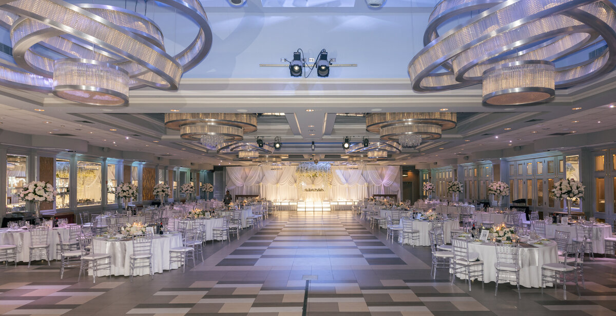 White tables at wedding reception with lots of white florals