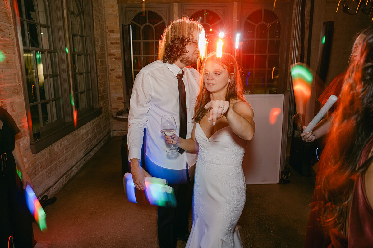 Editorial photo of bride and groom in fun red and shutter drag at their wedding after party.