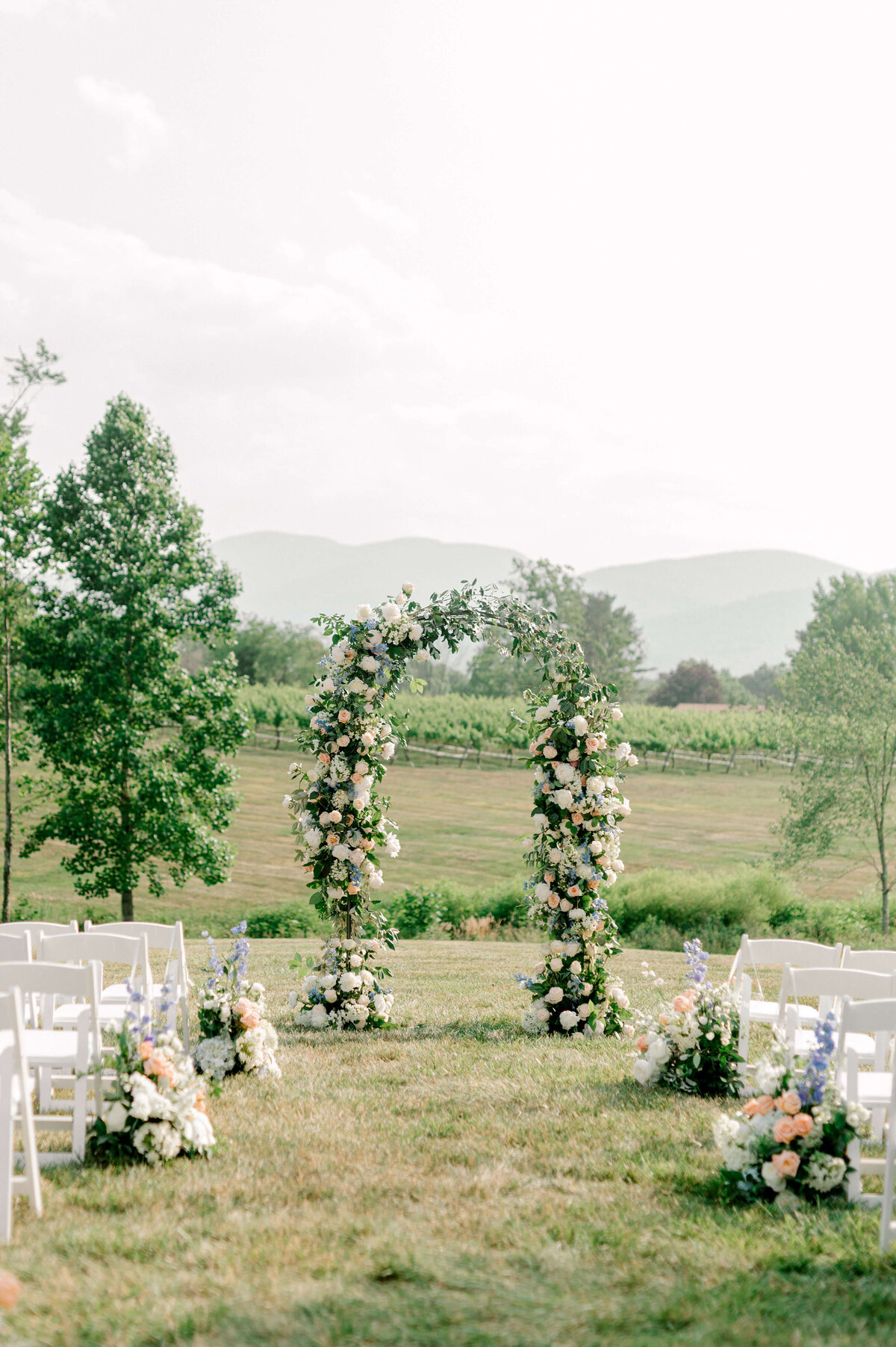 Wedding ceremony site with a flower arch set up at winery venue outside of DC
