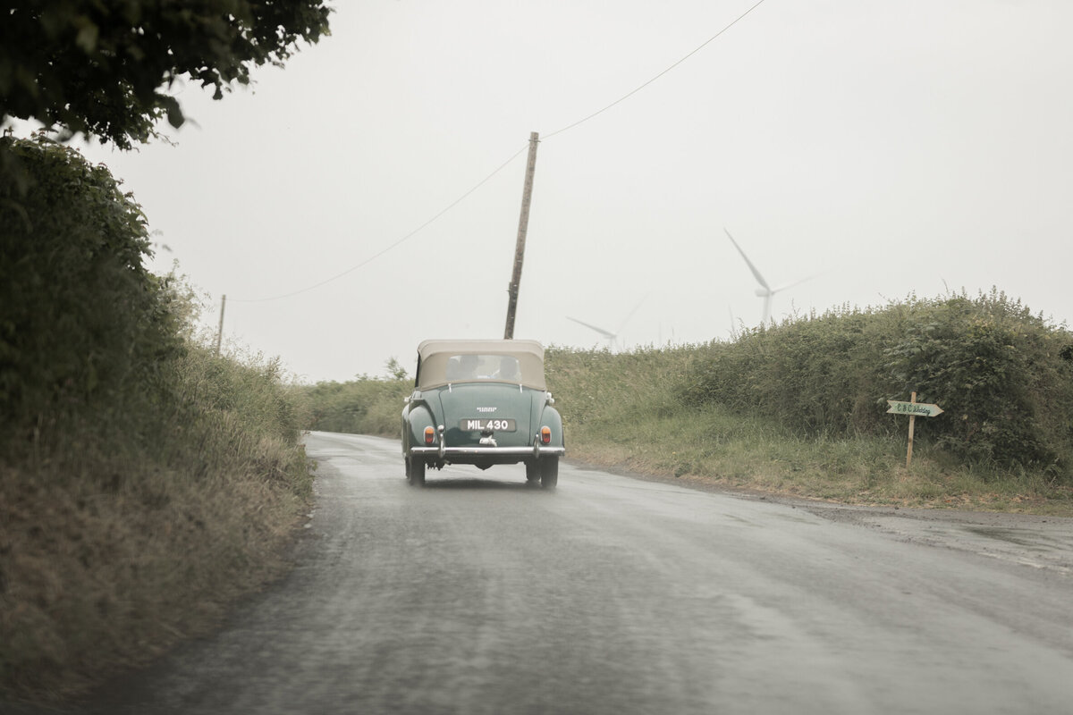 Wedding car driving in the rain at Devon wedding