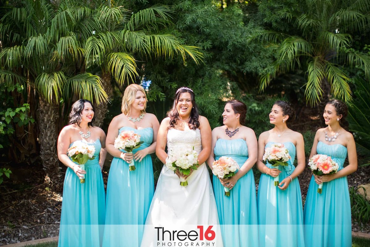 Bride and her Bridesmaids share a laugh as they pose together