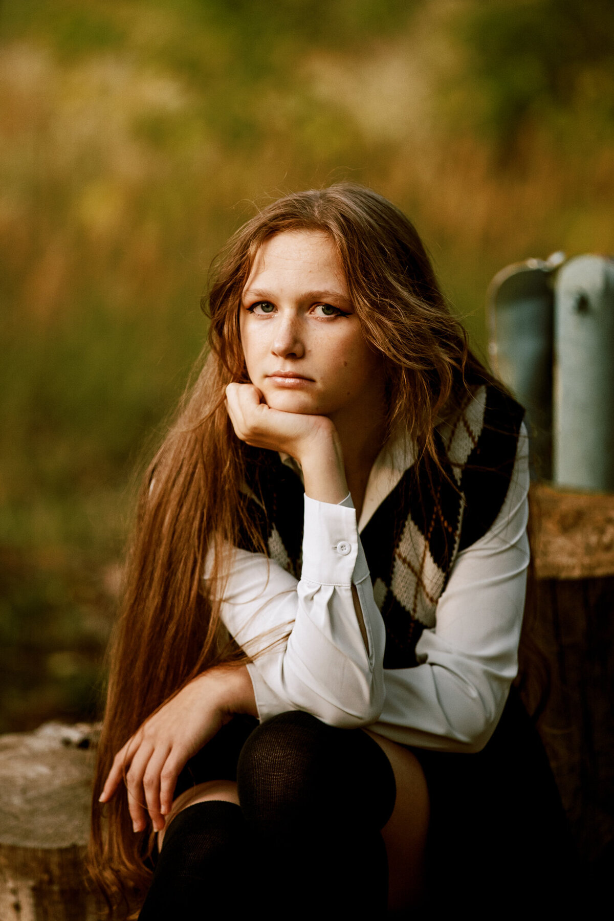 girl with long hair and a vest poses for a photo