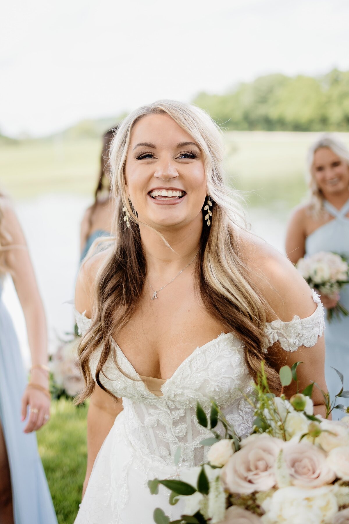 Bride smiles with bridesmaids at wedding