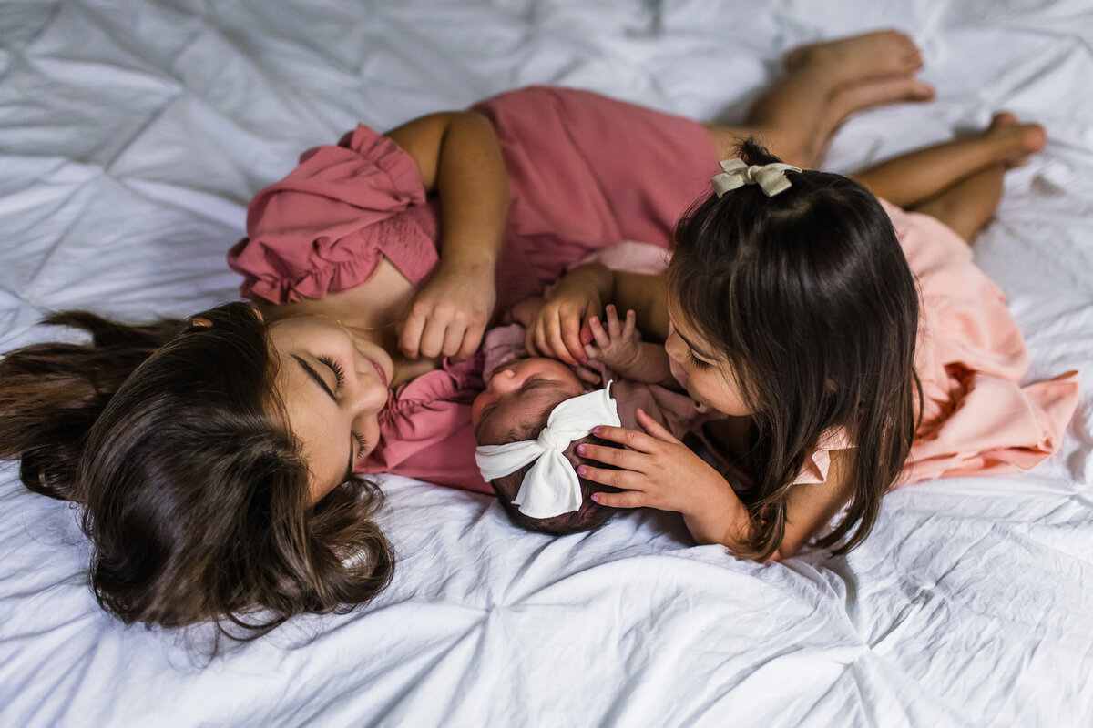 sweet sisters with their new baby