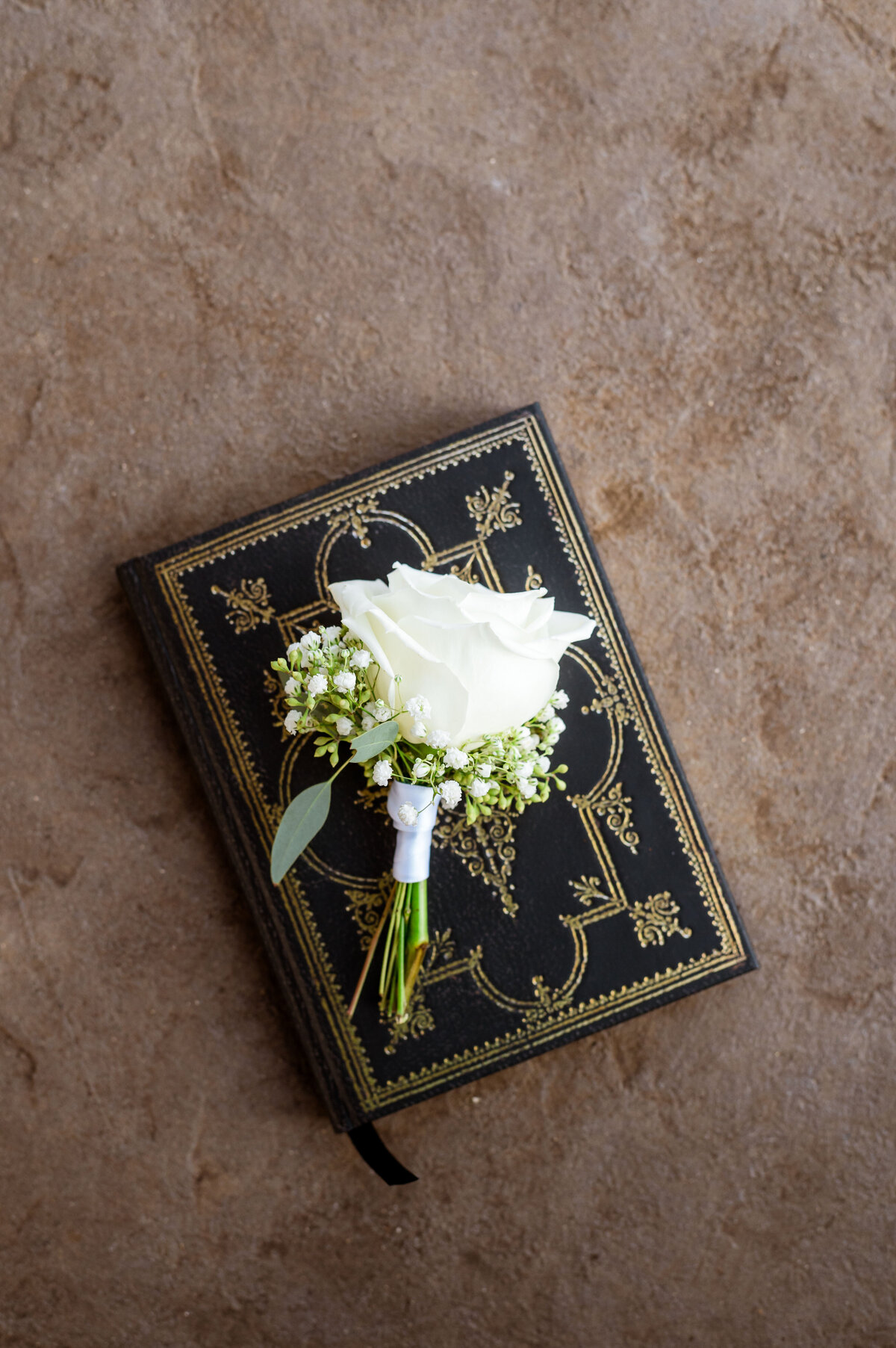 White rose boutonniere on book