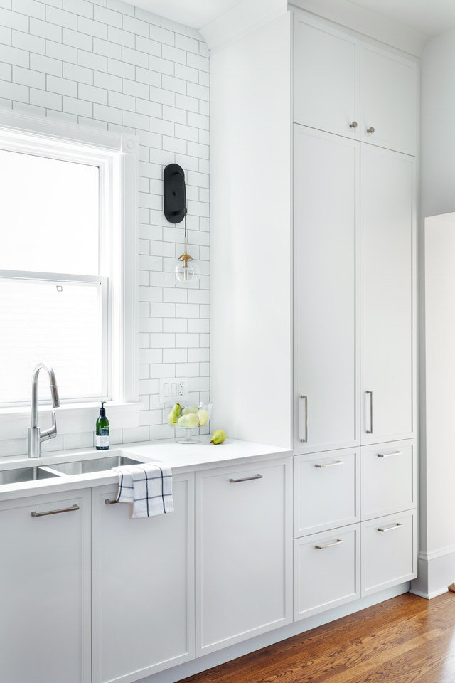 White kitchen cabinets - subway tiles - black sconces