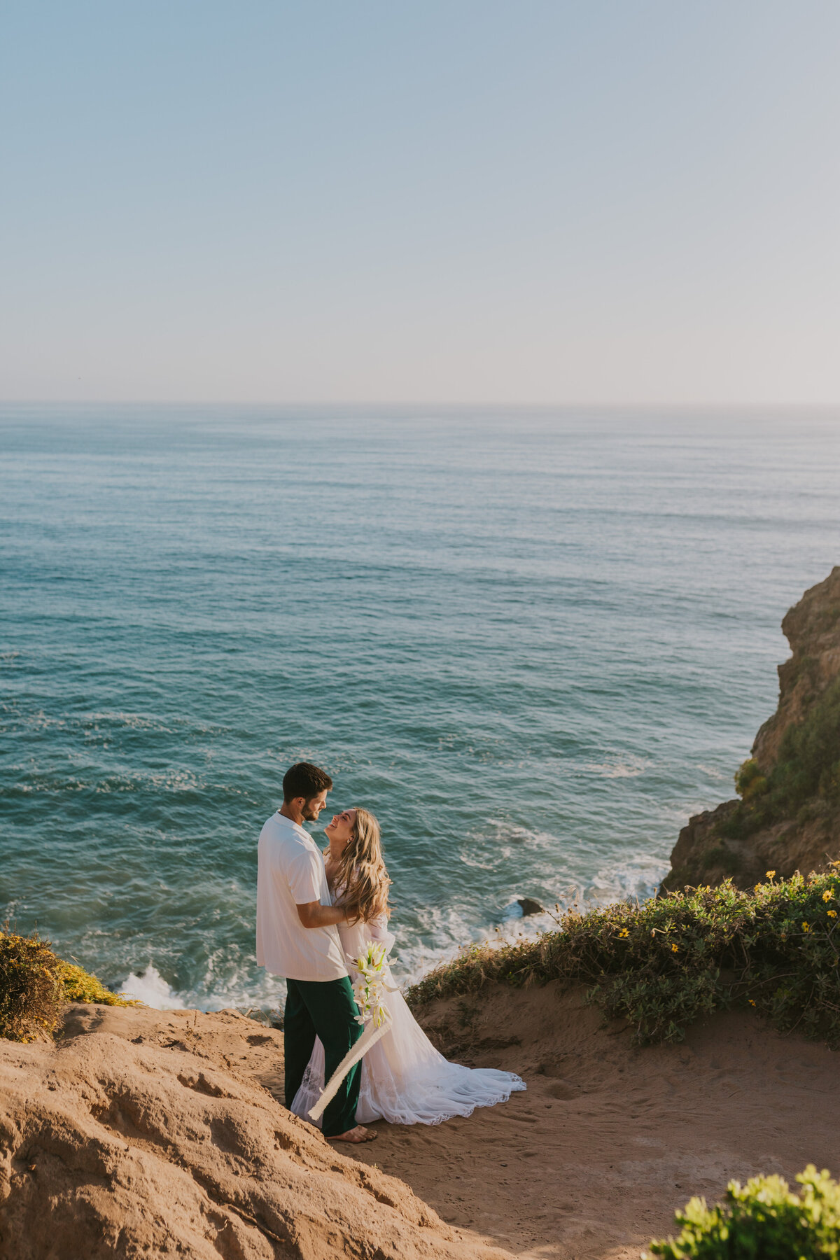 Couple holding each other by the ocean cliffs, scenic engagement shoot in Indiana.