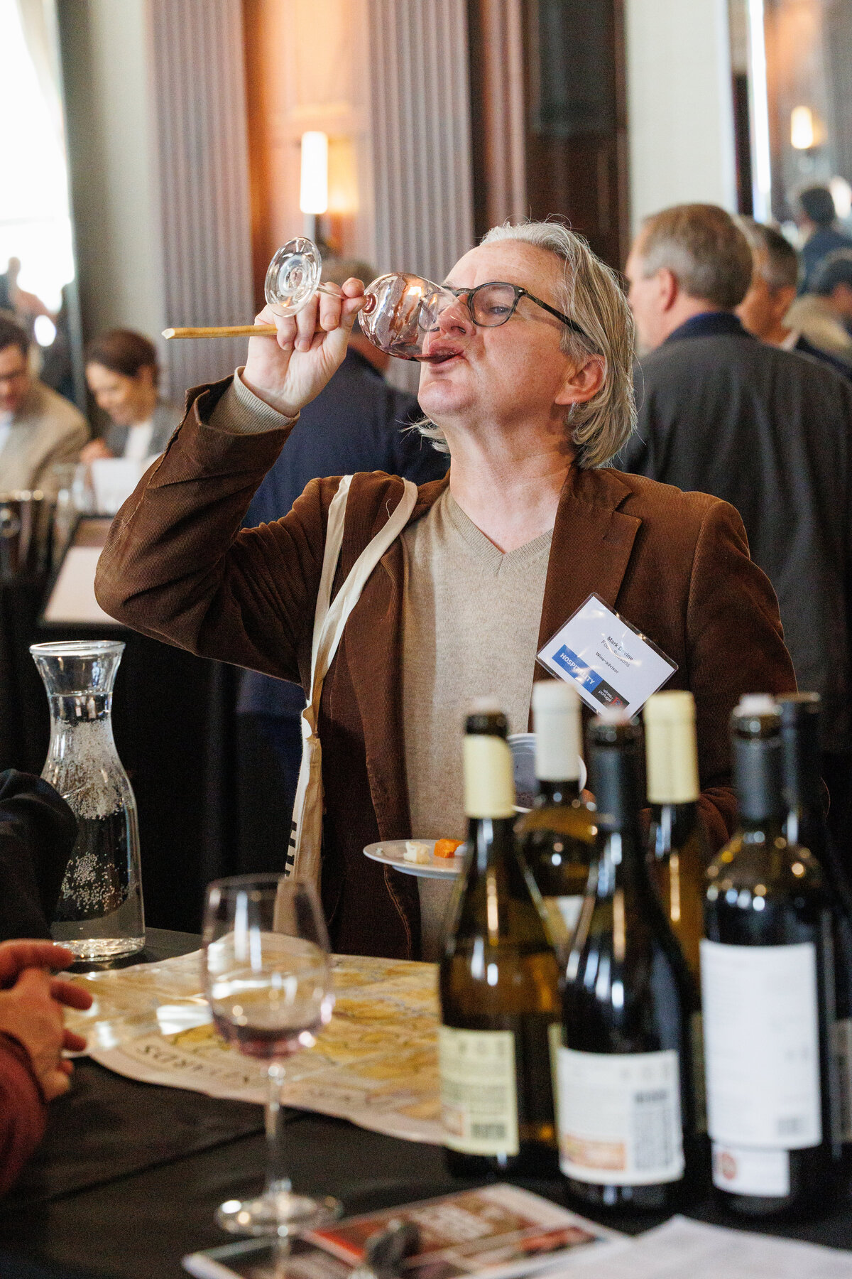 an older male drinking wine
